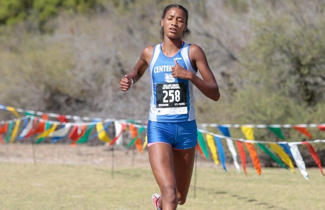 Centennial High School cross country runner Alexis Gourrier (258) runs across finish line to ...