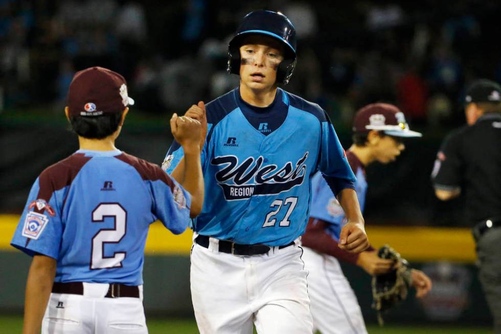 Las Vegas' Brennan Holligan (27) is greeted by Philadelphia third baseman Jack Rice (2) as he r ...