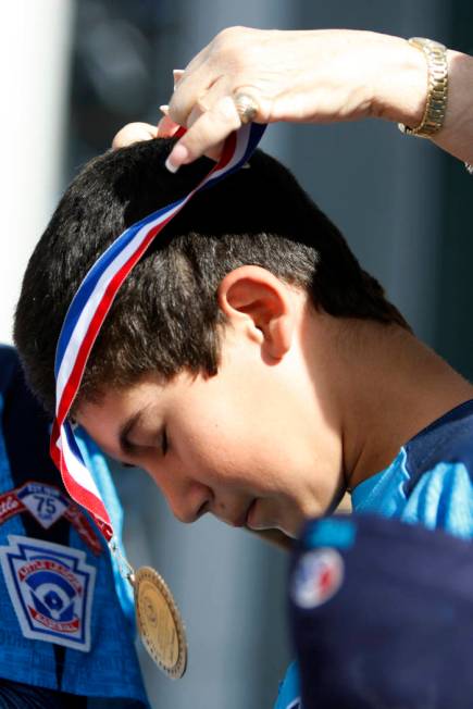 Mountain Ridge Little League player Josiah Cromwick (7) receives a medal from Las Vegas Mayor C ...