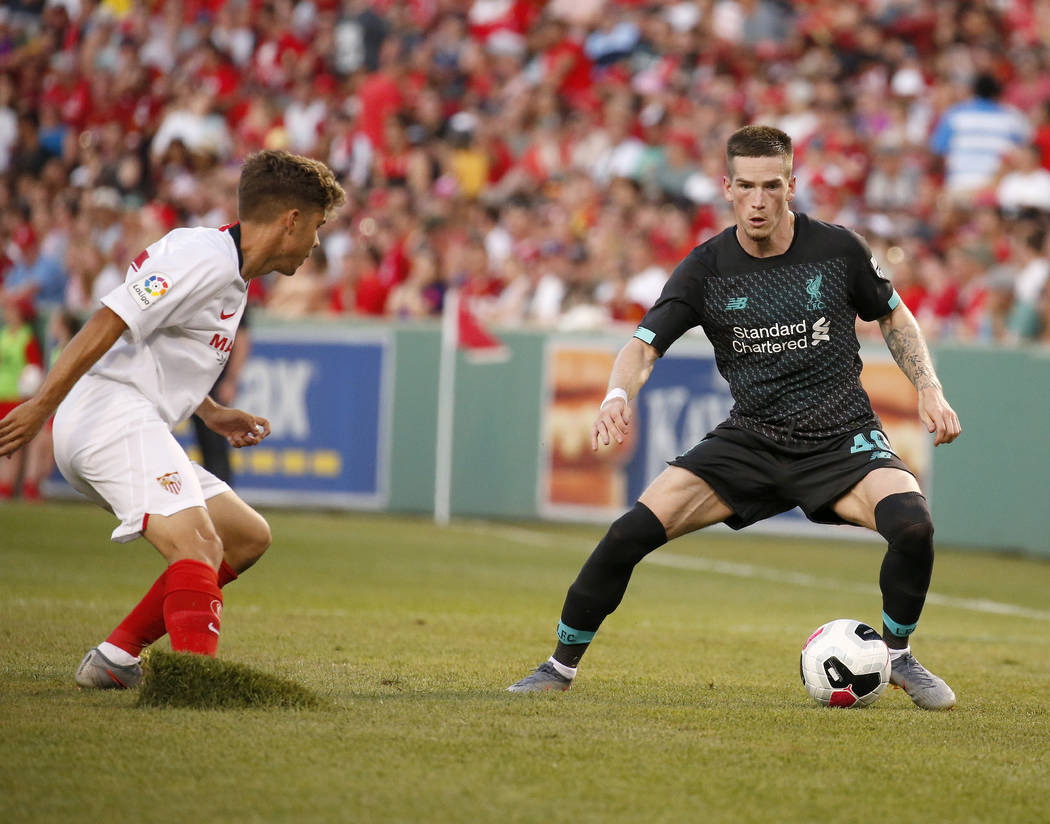 Sevilla's Alejandro Pozo, left, kicks up a piece of sod as he defends Liverpool's Ryan Kent (40 ...