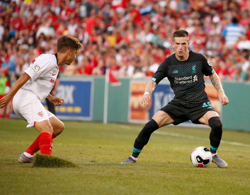 Sevilla's Alejandro Pozo, left, kicks up a piece of sod as he defends Liverpool's Ryan Kent (40 ...