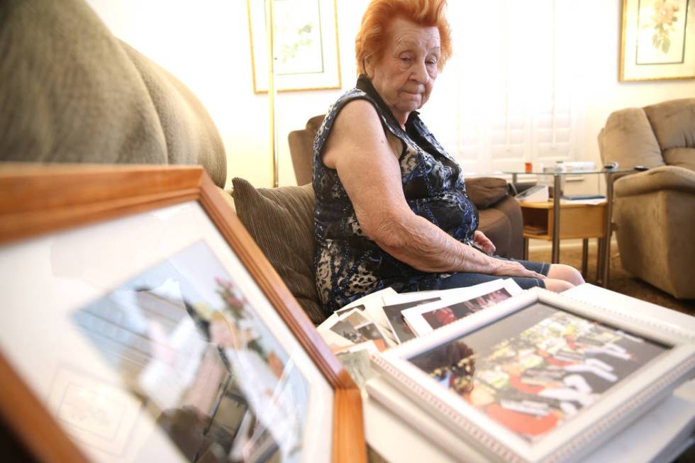 Etta Baykara, 91, shows family photos at her home in Las Vegas, Wednesday, Aug. 7, 2019. (Erik ...