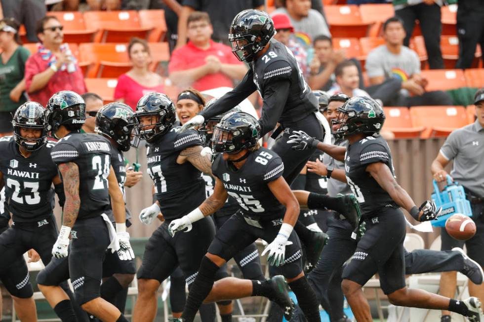 The Hawaii bench celebrates after Hawaii defensive back Kai Kaneshiro (24) intercepted an Arizo ...