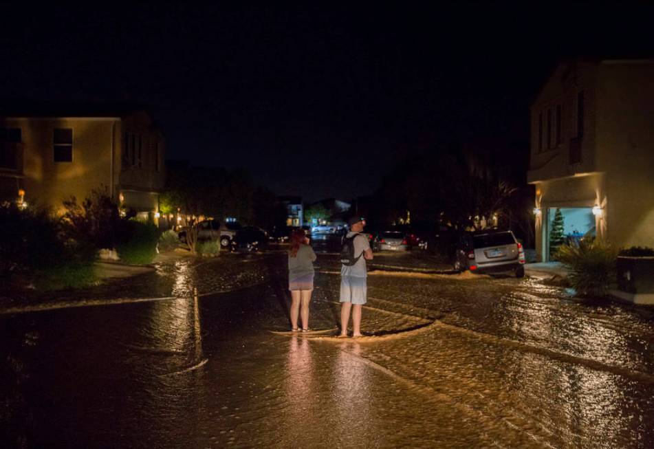 Southwest valley residents watch floodwaters flow past their homes near the intersection of Wes ...