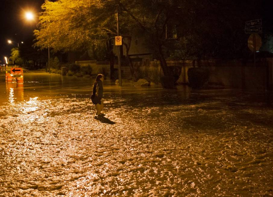 A southwest valley resident tries to cross floodwaters nearing three feet deep at the intersect ...