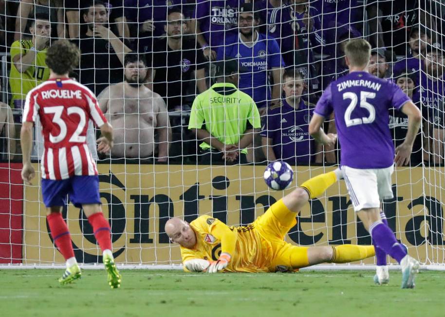 Atlanta United goalkeeper Brad Guzan, center, blocks a shot by Atletico Madrid midfielder Rodri ...