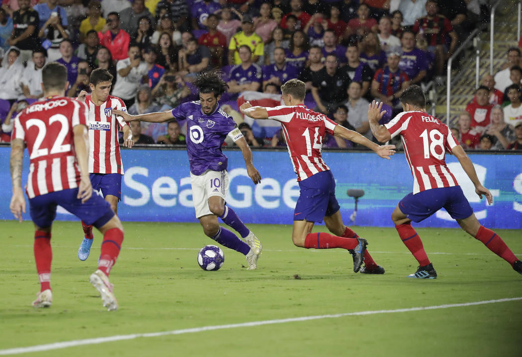 Los Angeles FC forward Carlos Vela (10) tries to moves the ball past Atletico Madrid midfielder ...