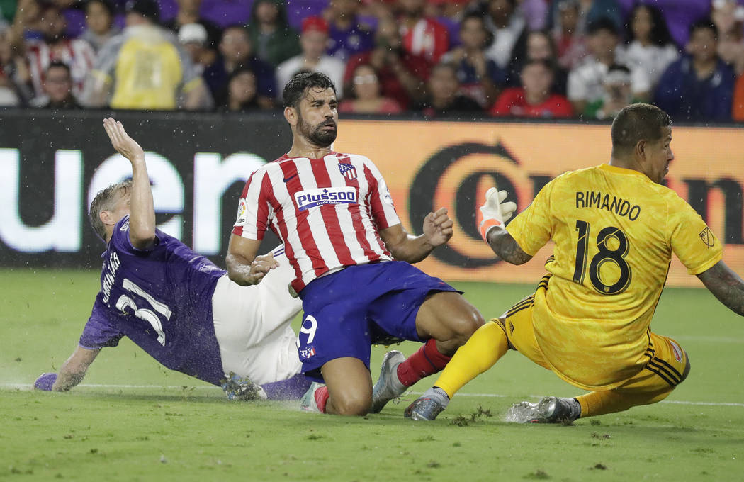Atletico Madrid forward Diego Costa, center, watches his shot go past Chicago Fire defender Bas ...