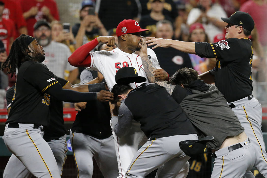 Cincinnati Reds relief pitcher Amir Garrett (50) looks to throw a punch as he is held back by a ...