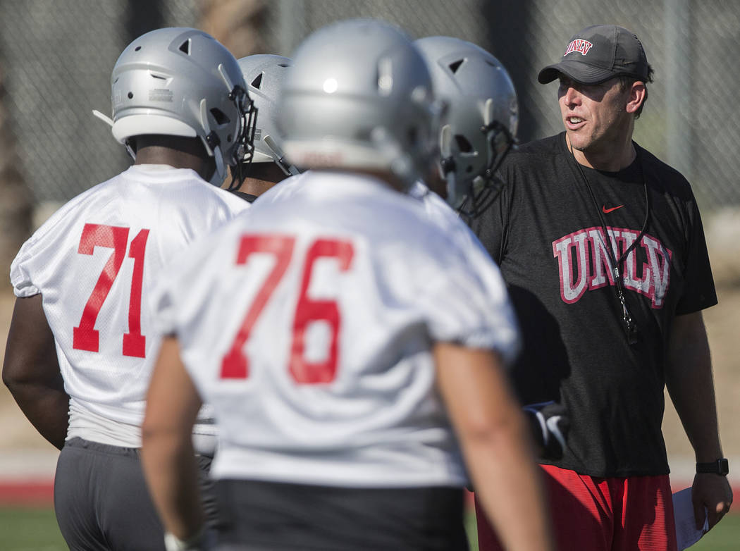 UNLV offensive coordinator Garin Justice, right, coaches up the Rebels during the first day of ...