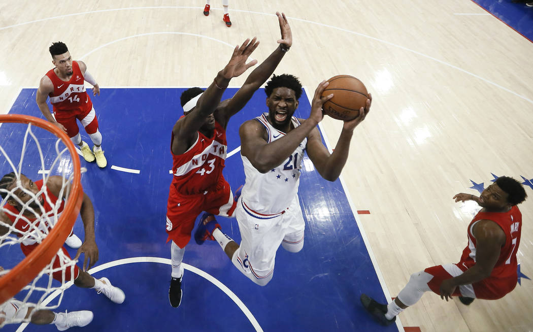 Philadelphia 76ers' Joel Embiid (21) goes up for a shot against Toronto Raptors' Pascal Siakam ...