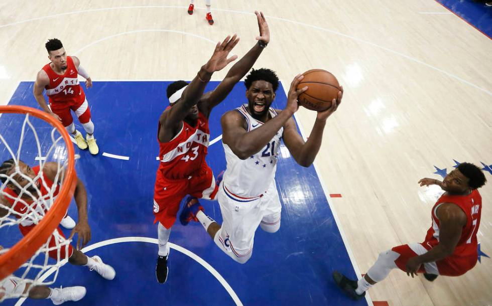 Philadelphia 76ers' Joel Embiid (21) goes up for a shot against Toronto Raptors' Pascal Siakam ...