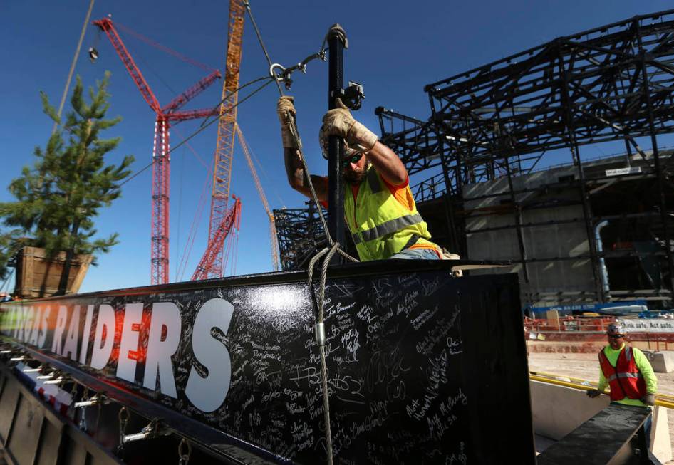 Zac Carter, iron worker with Local 597, secures a steel beam during the Las Vegas Stadium Toppi ...