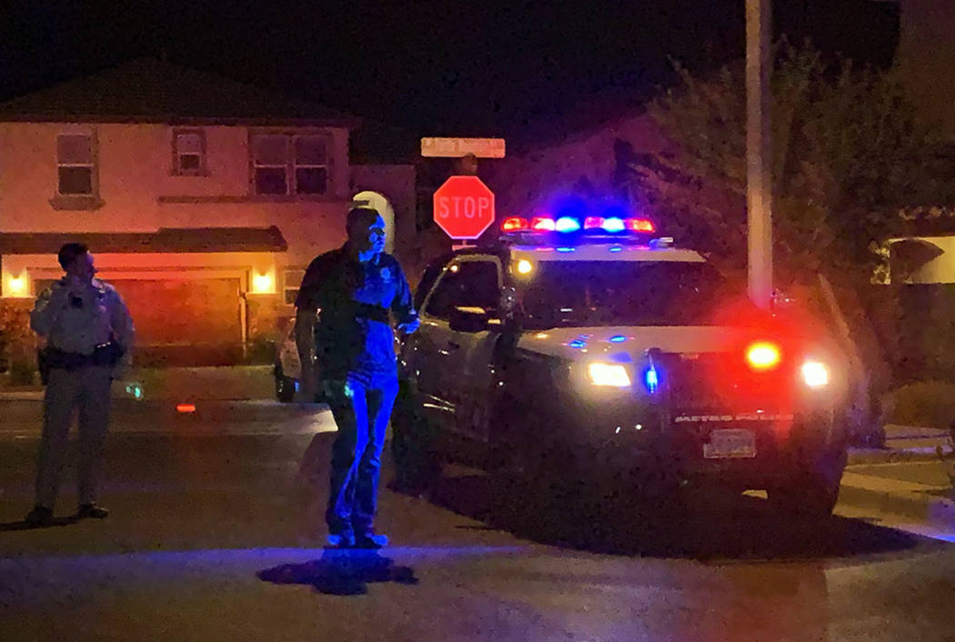 Police officers investigate after two people were found dead at a home in the 7800 block of Air ...