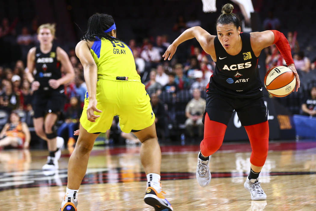 Las Vegas Aces' Kayla McBride drives to the basket against Dallas Wings' Allisha Gray (15) duri ...