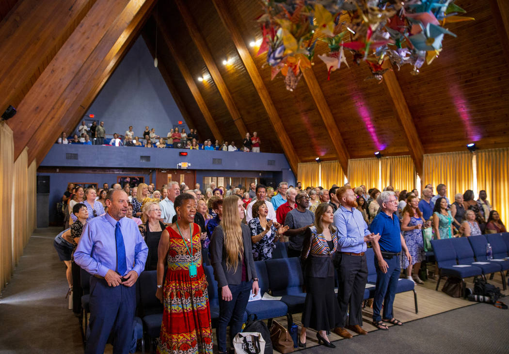 Democratic presidential candidate Marianne Williamson, center in front, joins the congregation ...