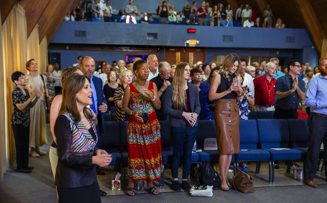 Democratic presidential candidate Marianne Williamson, center in front, joins the congregation ...