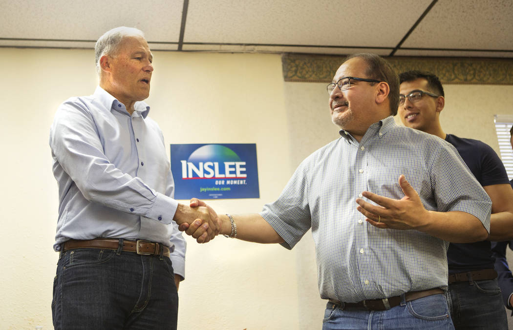 Democratic presidential candidate Washington Gov. Jay Inslee shakes the hand of the former Pres ...