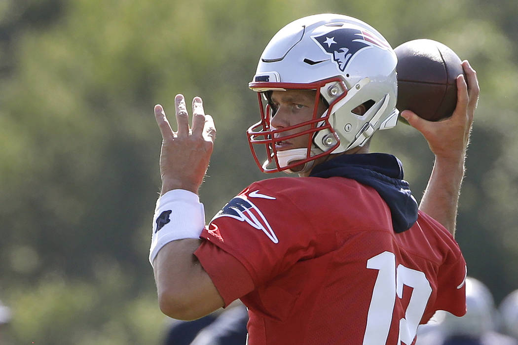New England Patriots quarterback Tom Brady winds up to pass the ball during an NFL football tra ...