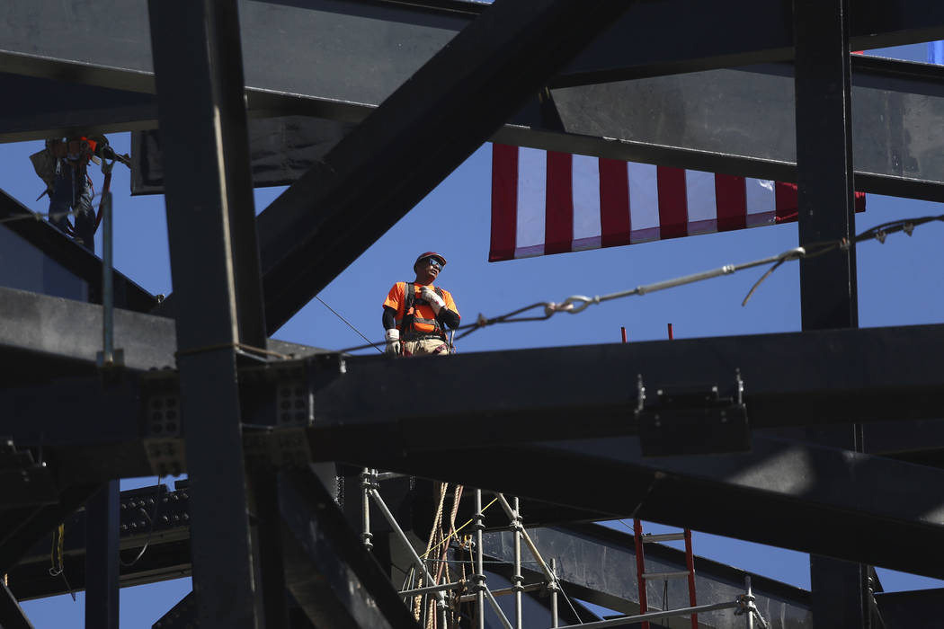 A worker helps install a steel beam during the Las Vegas Stadium Topping Out Ceremony in Las Ve ...