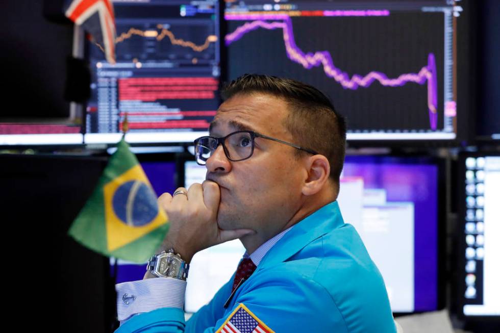 Specialist Paul Cosentino works on the floor of the New York Stock Exchange, Monday, Aug. 5, 20 ...