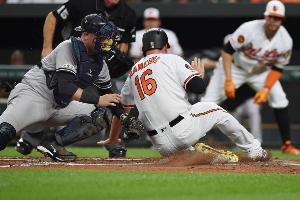 Baltimore Orioles' Trey Mancini (16) is tagged out by New York Yankees catcher Austin Romine, l ...