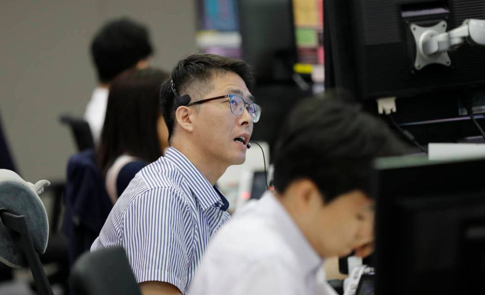 A currency trader talks on the phone at the foreign exchange dealing room in Seoul, South Korea ...