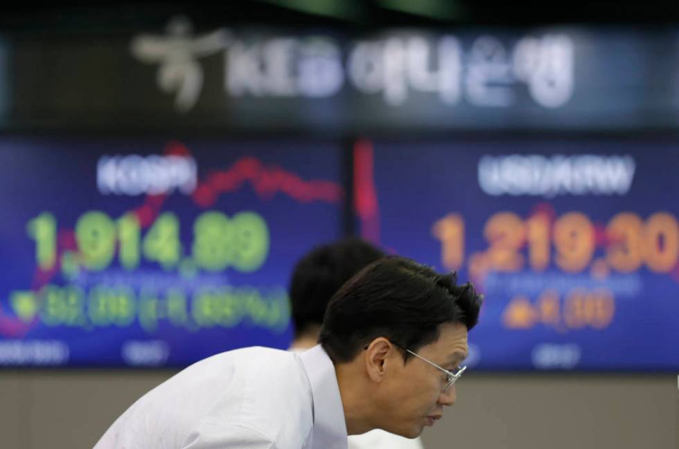 A currency trader watches the computer monitors near the screens showing the Korea Composite St ...