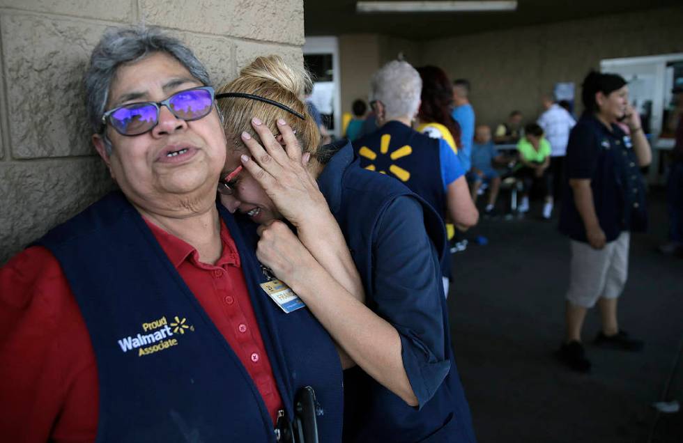 In an Aug. 3, 2019, file photo Walmart employees react after an active shooter opened fire at t ...