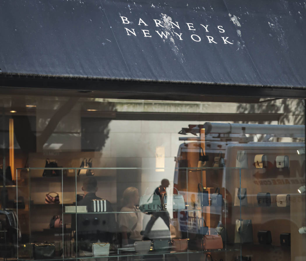 FILE - In this July 16, 2019, file photo a pedestrian reflect in a store window at Barneys depa ...