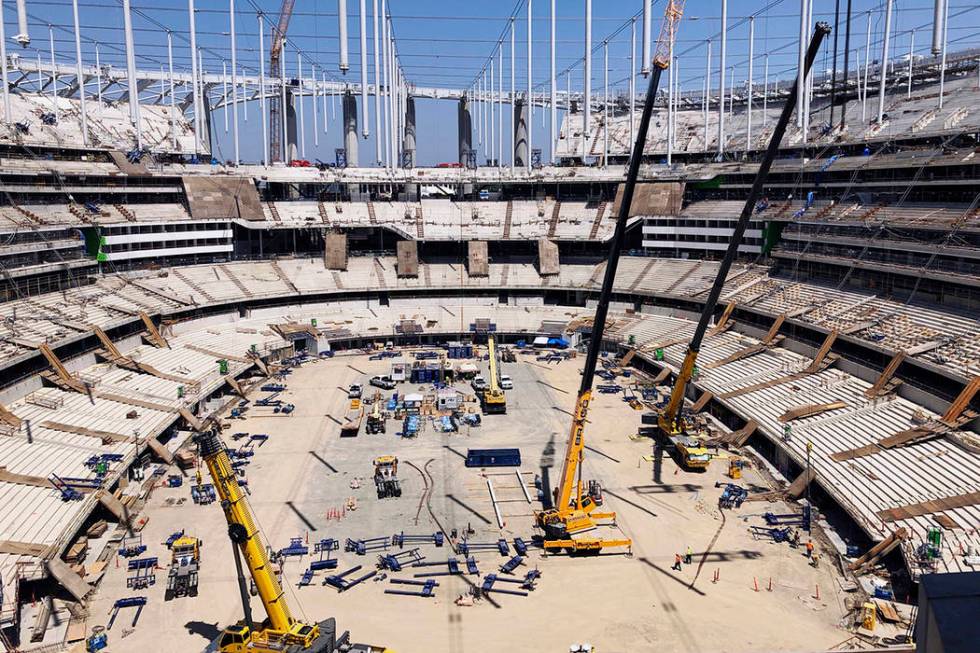 Construction workers continue work in the bowl of the NFL stadium rising in Inglewood, Calif., ...