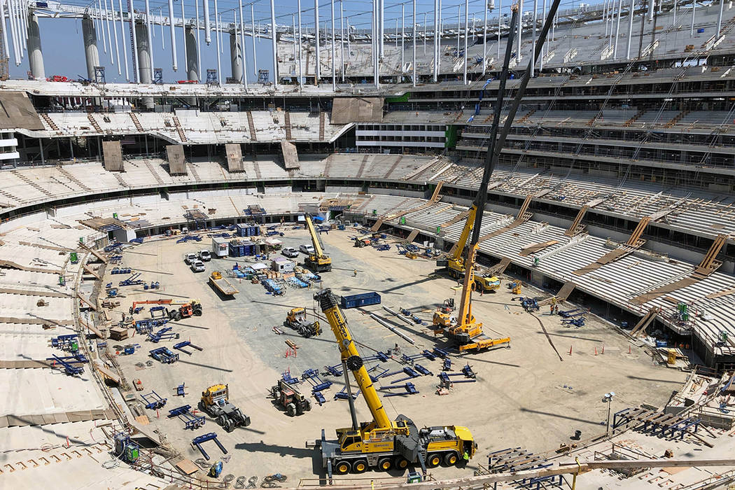 Construction workers continue work in the bowl of the NFL stadium rising in Inglewood, Calif., ...