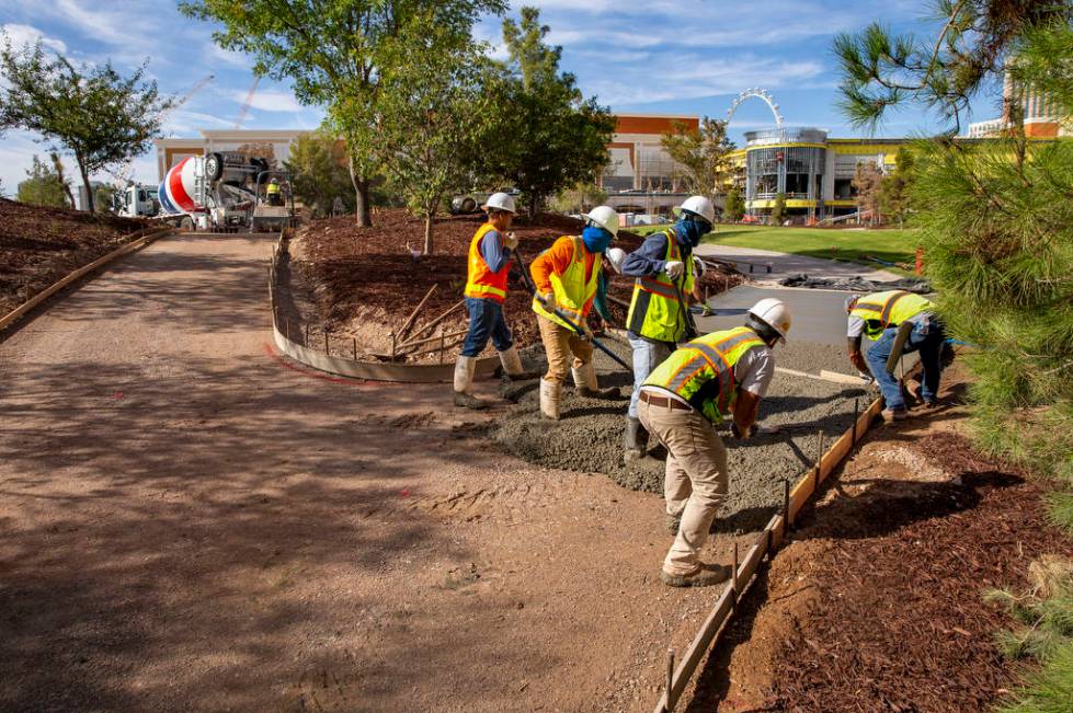 Construction crew lay a concrete path at Wynn Golf Club on Tuesday, July 30, 2019, in Las Vegas ...