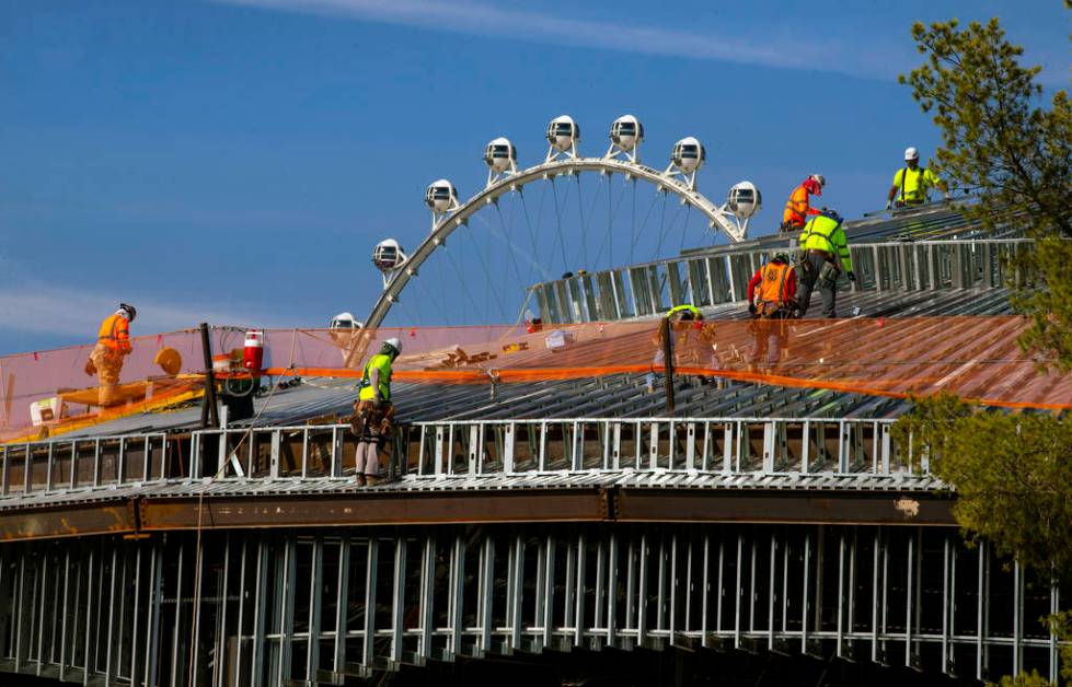 A construction crew works on the roof of a new pavilion at Wynn Golf Club on Tuesday, July 30, ...