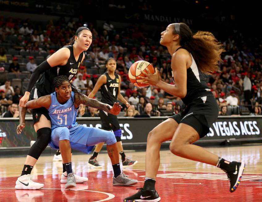 Las Vegas Aces' Jisu Park (19) is blocked by Atlanta Dream's (51) Jessica Breland as teammate J ...