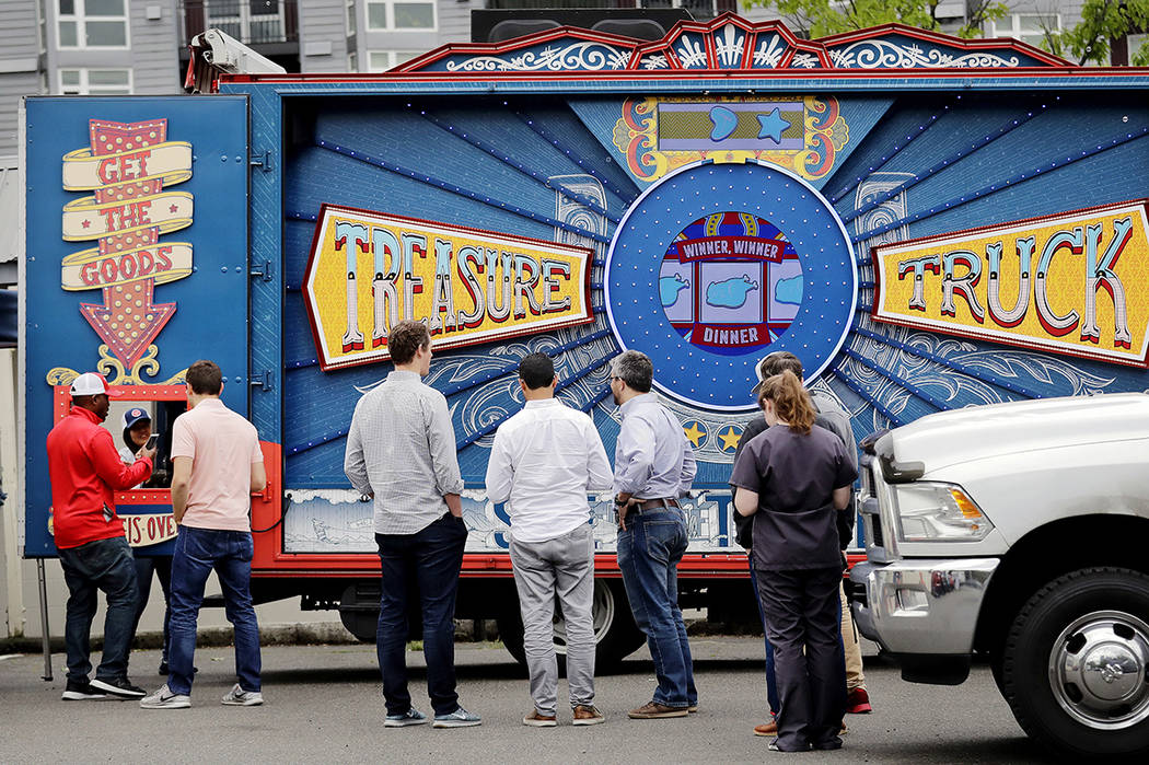 Photo customers line-up to pick-up their deal of the day purchase at an Amazon Treasure Truck a ...