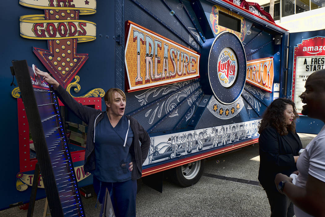 An office worker plays a carnival game for a free sample at an Amazon Treasure Truck at The Par ...