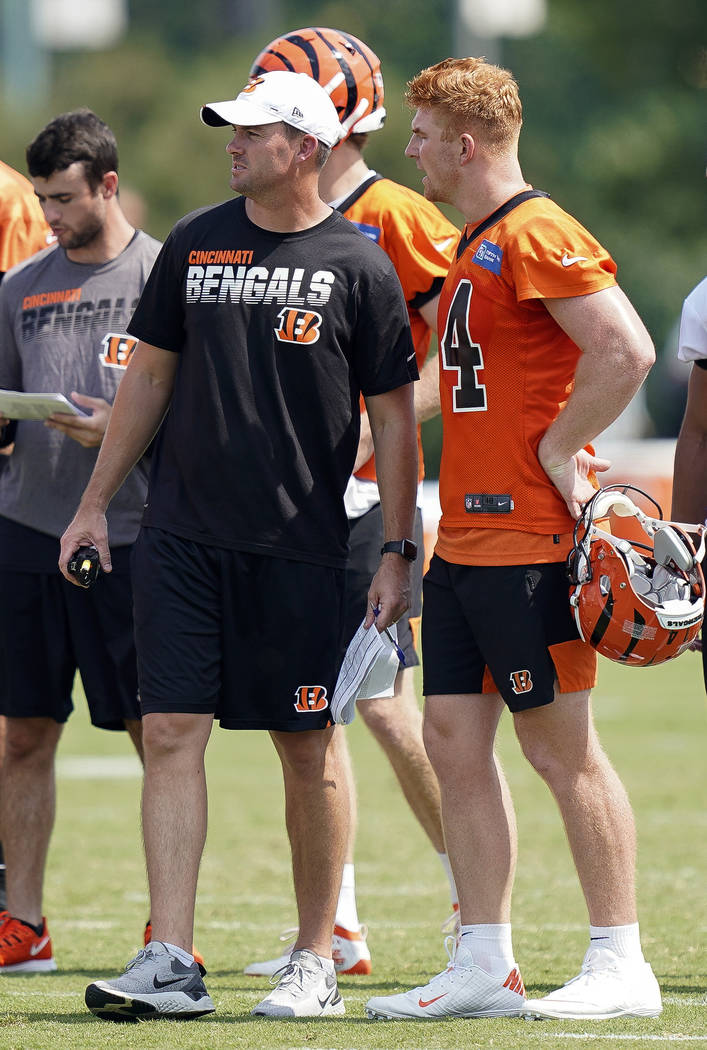 Cincinnati Bengals head coach Zac Taylor, front left, and quarterback Andy Dalton, right, talk ...