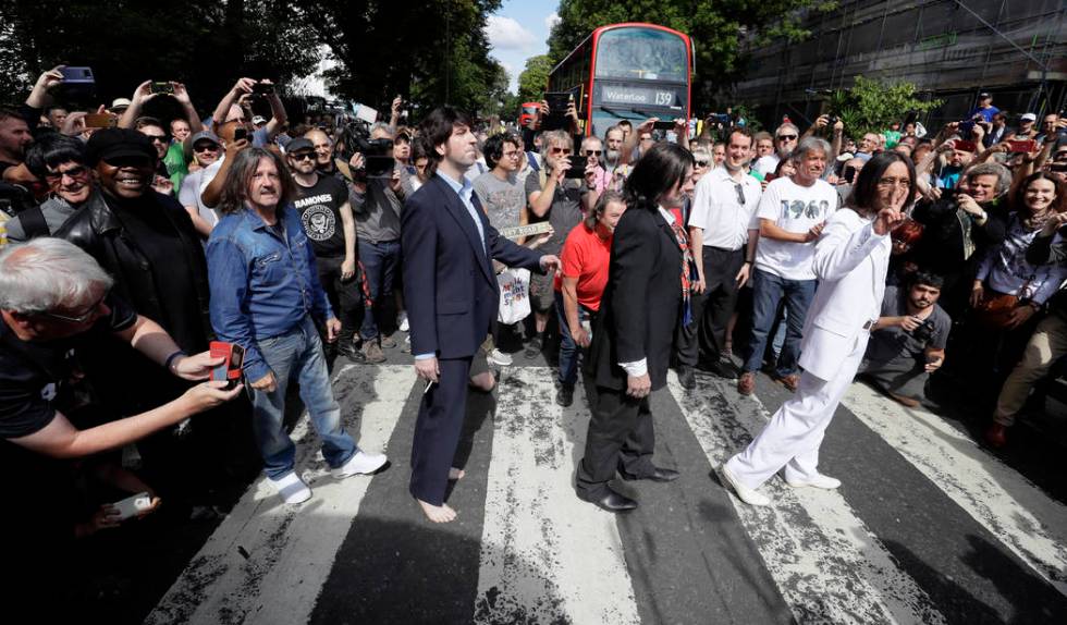 Fans dressed as lookalikes walk across the Abbey Road zebra crossing on the 50th anniversary of ...