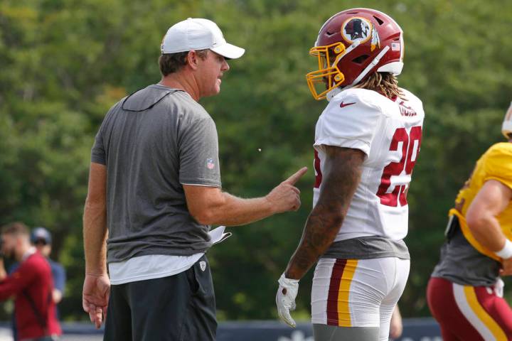 Washington Redskins head coach Jay Gruden, left, talks with running back Derrius Guice (29) dur ...