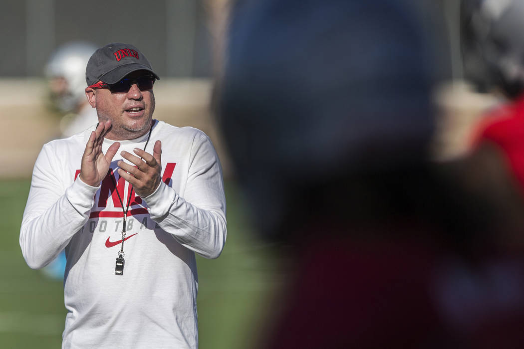 UNLV head football coach Tony Sanchez, left, fires up his team during the first day of training ...