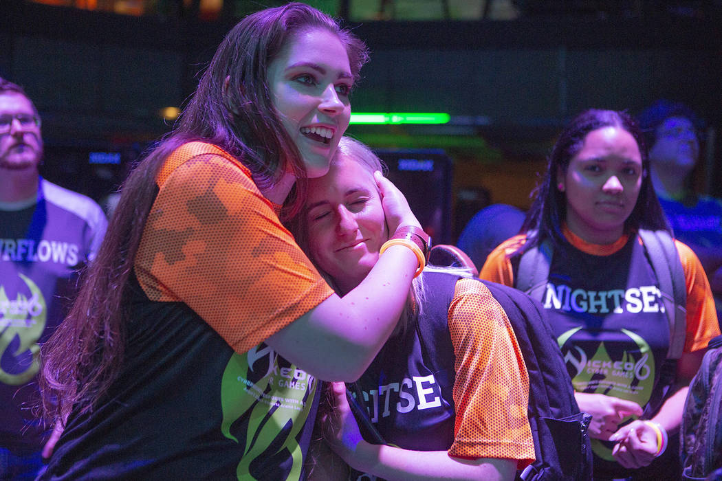 Lauryn Landkrohn 22, hugs fellow Knightsec teammate Sydney Munro, 23, both from the University ...
