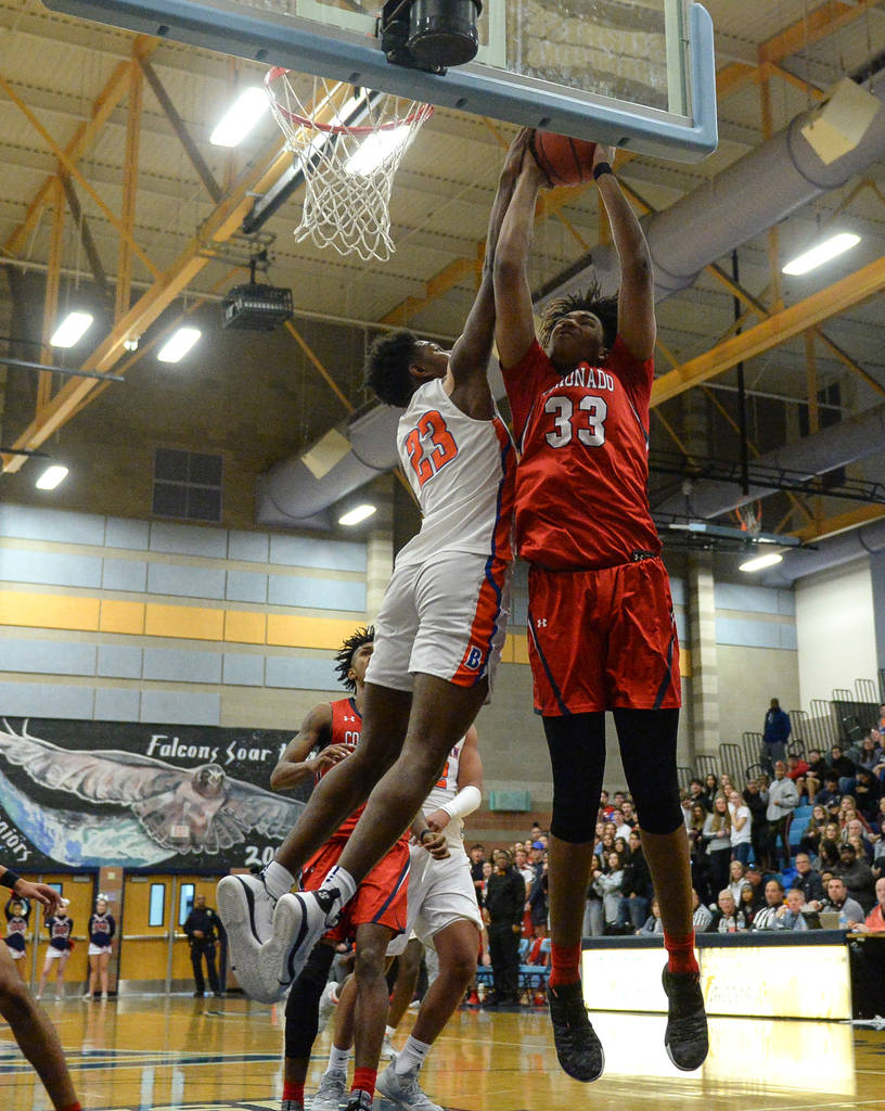 Coronado's Jhaylon Martinez (33) jumps up to take a shot while being guarded by Bishop Gorman's ...