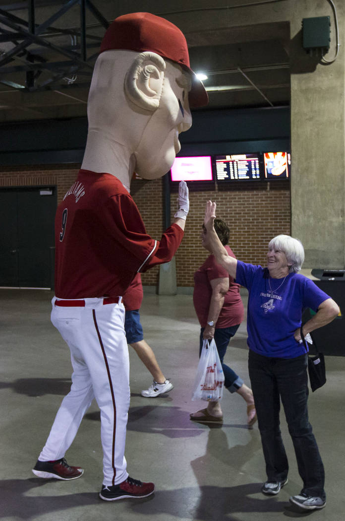 Cindy McBride, of Phoenix, high-fives the oversized mascot representing Diamondbacks' Matt Will ...