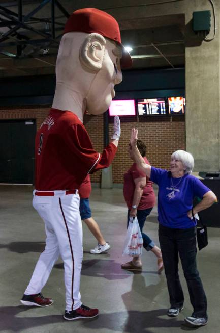 Cindy McBride, of Phoenix, high-fives the oversized mascot representing Diamondbacks' Matt Will ...