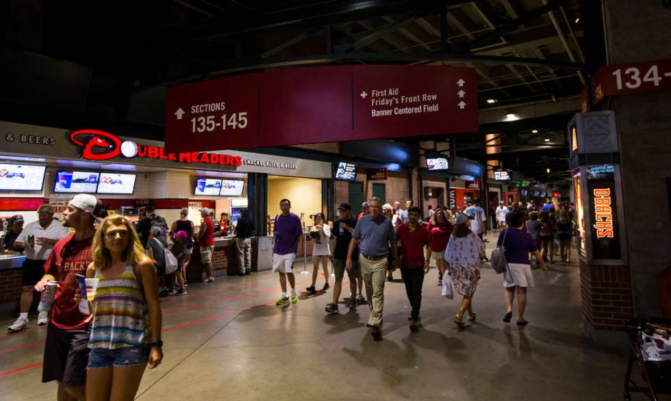 Fans walk the concourse before the start of an Arizona Diamondbacks baseball game against the P ...