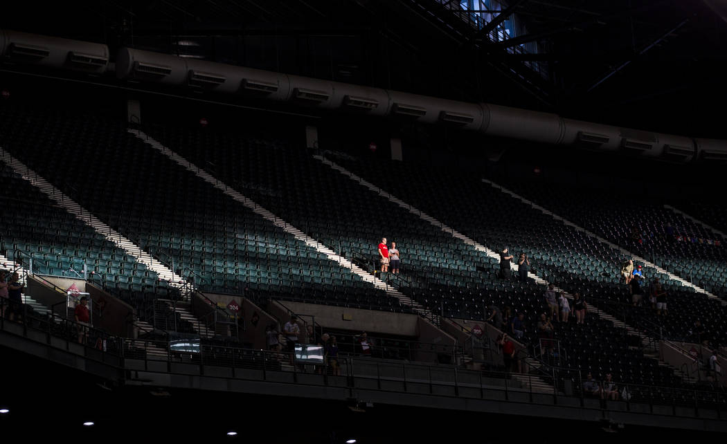 Fans are highlighted by a strip of sunlight before the start of an Arizona Diamondbacks basebal ...