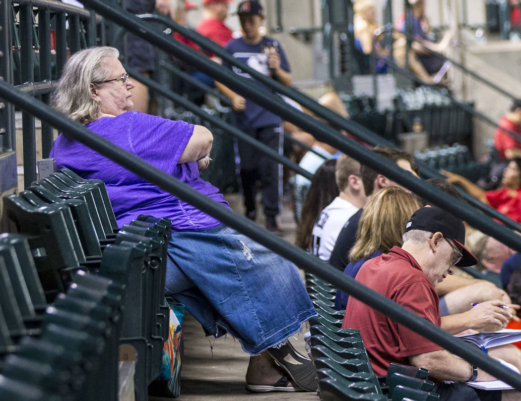 Jackie Laird, of Phoenix, in purple, watches the action during an Arizona Diamondbacks baseball ...