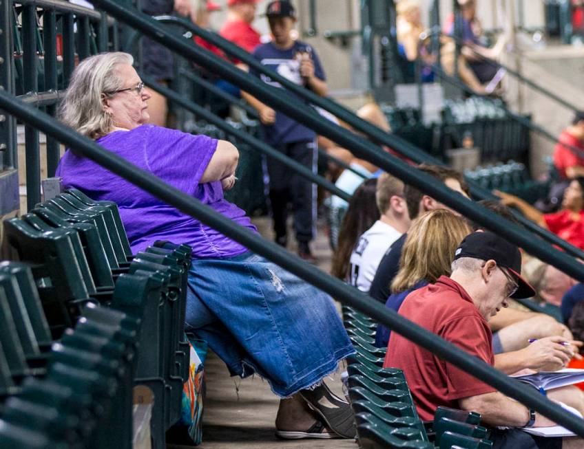 Jackie Laird, of Phoenix, in purple, watches the action during an Arizona Diamondbacks baseball ...