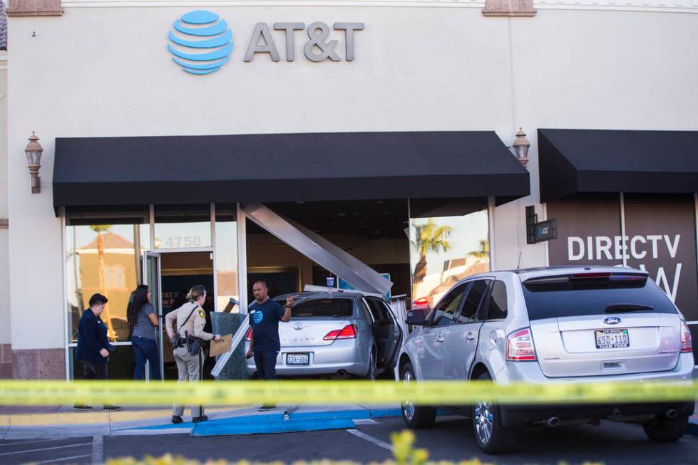 Las Vegas police investigate the scene where a driver in a car crashed into an AT&T store i ...